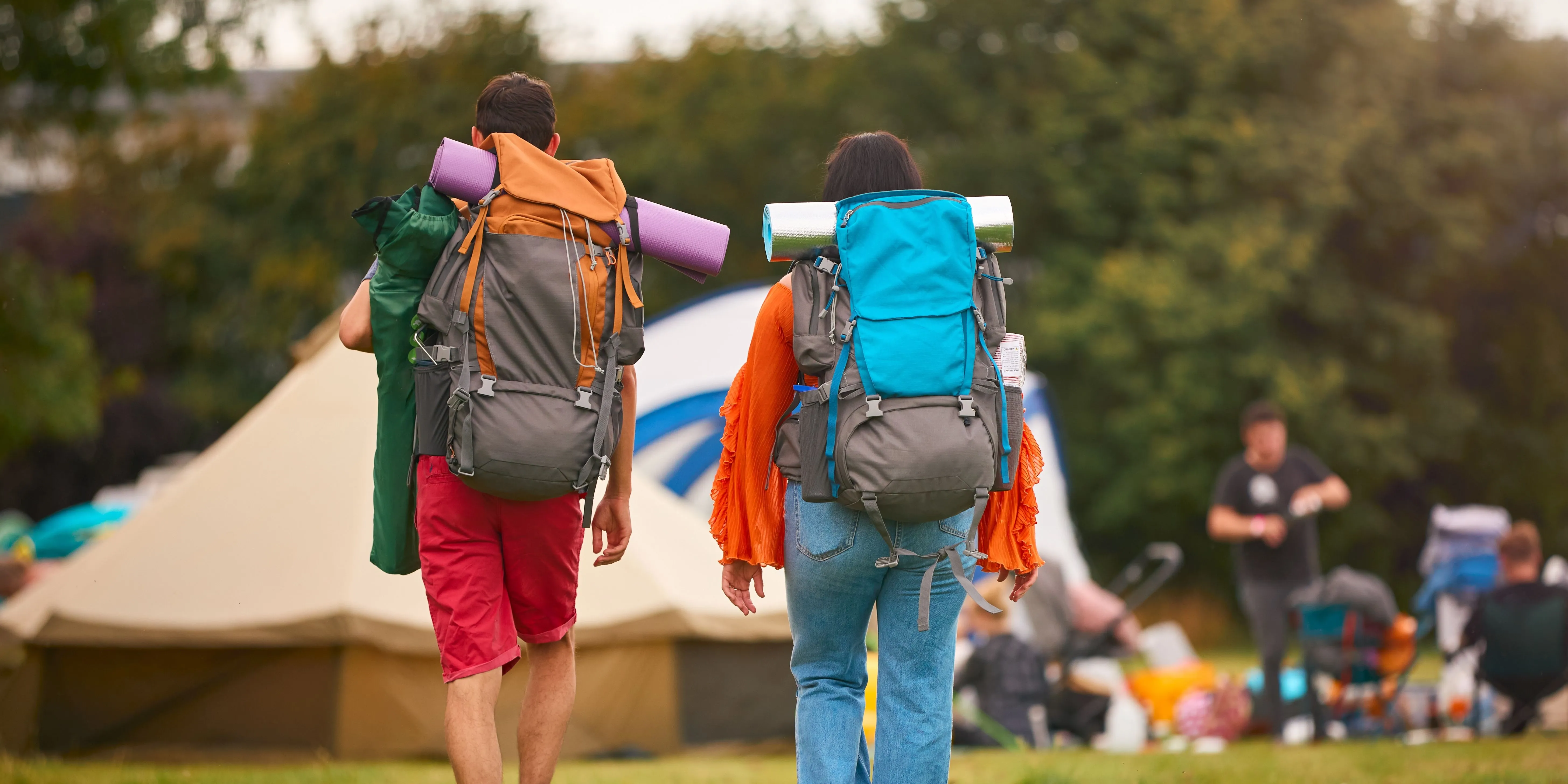Billede af 2 der har tasker på til en festival.